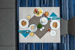Hotel Lumi في فريبورغ ام بريسغاو: طاولة عليها أطباق من المواد الغذائية والمشروبات