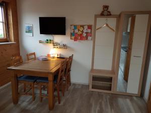 una sala da pranzo con tavolo, sedie e TV di Ferienwohnung Erkelenz a Erkelenz