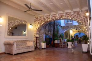vestíbulo con sofá y pared de ladrillo en Casa Villa Colonial By Akel Hotels, en Cartagena de Indias