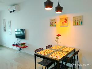 a dining room table with a flower vase on it at Apartel opp Spice Arena in Bayan Lepas