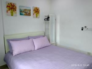 a bedroom with a purple bed with two pictures on the wall at Apartel opp Spice Arena in Bayan Lepas