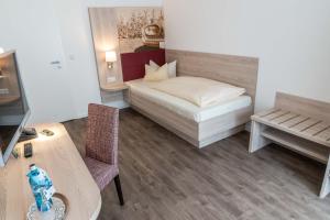 a small room with a bed and a table at Frommanns Landhotel in Buchholz in der Nordheide