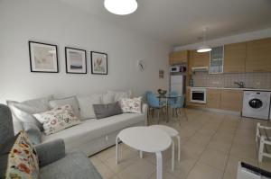 uma sala de estar com um sofá e uma cozinha em Blue Dawn Center Flat em Lárnaca