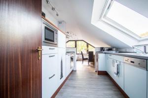 a kitchen with white appliances and a skylight at Ferienwohnung Konrad Duden in Wesel