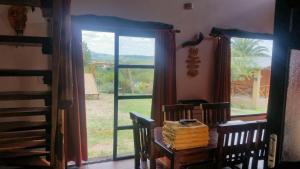 a dining room with a table and a large window at Estrella del Alma in Capilla del Monte