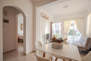 ein weißes Esszimmer mit einem Tisch und Stühlen in der Unterkunft Beautiful one bed apartment in Paphos in Paphos City