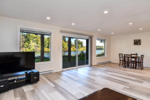 a living room with a flat screen tv and wooden floors at Chateau Riverside in Campbell River