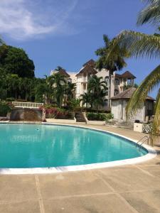 a large swimming pool in front of a house at Sky Castles Apt H6 in Ocho Rios