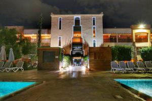 un hôtel avec une piscine, des chaises et un bâtiment dans l'établissement Club Paradisio, à Marrakech