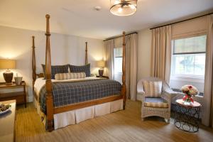 a bedroom with a bed and a chair and a window at Pillar and Post Inn & Spa in Niagara-on-the-Lake