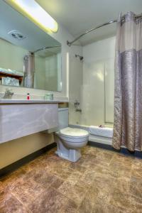 a bathroom with a toilet and a shower and a tub at Super 8 by Wyndham Jackson Hole in Jackson