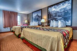 a hotel room with two beds and a large painting on the wall at Super 8 by Wyndham Jackson Hole in Jackson