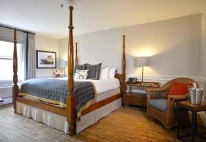 a bedroom with a bed and a chair in a room at Pillar and Post Inn & Spa in Niagara-on-the-Lake