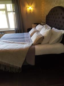 a bedroom with a bed with white pillows and a window at Bed and breakfast Mooi Achel in Achel