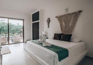 
a bedroom with a large bed and a large window at Xcacel Dreams in Chemuyil
