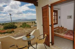 a room with a table and chairs and a large window at Pirgos Naxos in Aliko Beach