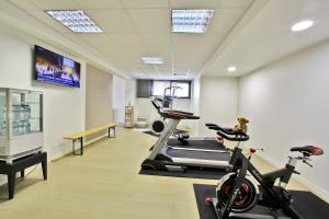 a gym with two exercise bikes and a treadmill at Logis Hôtel Restaurant Aloe in Les Herbiers