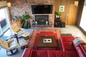 a living room with a red couch and a fireplace at Walls of Glass Hood Canal Vacation Rental in Union