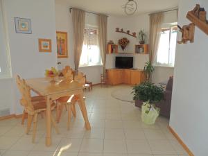 uma sala de estar com uma mesa de madeira e cadeiras em Appartamenti Casa Prandel em Levico Terme
