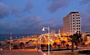 uma rua da cidade à noite com um edifício em Appart Hotel Excellent em Nador