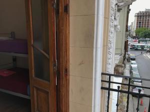 una puerta abierta a un edificio con balcón en Hostelmo Hotel en Buenos Aires
