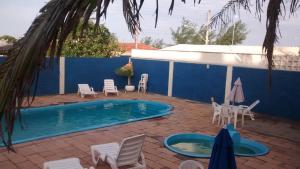 a patio with chairs and a swimming pool at Litoral Hotel in Arroio do Sal