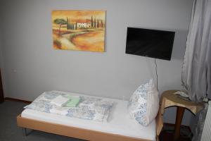 a room with a bed with a tv on the wall at Hotel Restaurant Balkan in Trier