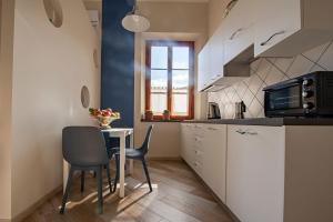 a kitchen with a table and chairs in a kitchen at Minerva Apartment in Casciana Terme