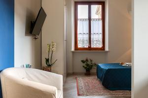 a living room with a tv and a couch and a window at Minerva Apartment in Casciana Terme