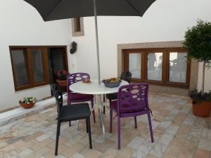 a table and chairs with an umbrella on a patio at A Casinha in Sintra