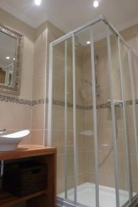 La salle de bains est pourvue d'une douche avec une porte en verre. dans l'établissement "Stine", à Westerland