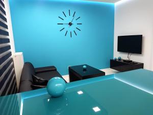 キェルツェにあるApartament Exclusive Blueのリビングルーム(テーブル、壁掛け時計付)