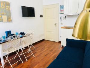 a living room with a table and chairs and a kitchen at In Piazza 'Apartments & Relax' in Ravenna