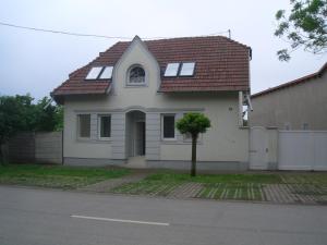 uma pequena casa branca com um telhado vermelho em Apartments-Mini-Hotel em Csongrád