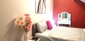 a bedroom with a bed and a vase of flowers at Gabriel Guesthouse in Rhyl