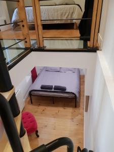 2 vistas para um pequeno quarto com uma cama e escadas em Appart Jardin en Ville Cœur de Nantes em Nantes