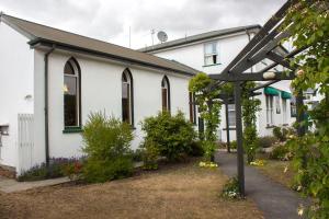 een wit gebouw met ramen en een tuin bij The Pier Lodge Bed And Breakfast in Christchurch