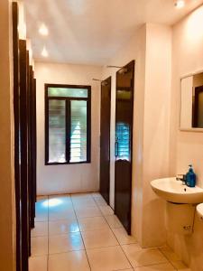 baño con lavabo y aseo y ventana en One Hostel - El Nido en El Nido