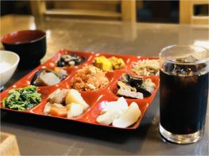 un plato de comida en una mesa junto a una bebida en Karuizawa Pension Sato no Nukumori, en Karuizawa