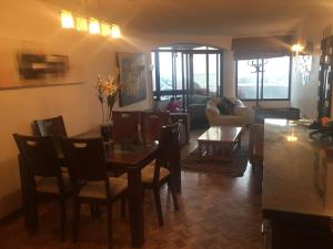 a living room with a table and chairs and a couch at Beachfront Apartment Reñaca Chile in Viña del Mar