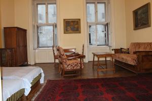 a bedroom with a bed and a couch and a chair at City Center Apartment in Budapest