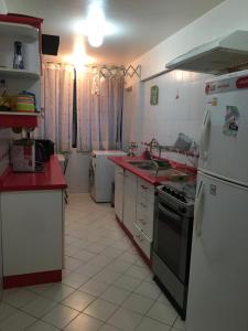 a kitchen with white appliances and red counter tops at Beachfront Apartment Reñaca Chile in Viña del Mar +20 photos