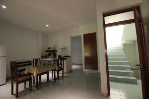 a living room with a table and chairs and a staircase at Bungalows de KQ in Xilitla