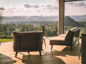 un soggiorno con 2 sedie e vista sulle montagne di Villa Strata a Kuta Lombok