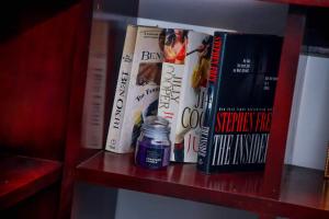 a shelf with books and a candle on it at Percy Residence in Unawatuna