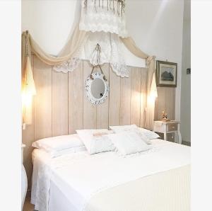 1 dormitorio con cama blanca y lámpara de araña en B&B Lido, en Gallipoli