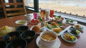 una mesa con platos de comida y tazones de comida en Shirakabako View Hotel, en Tateshina