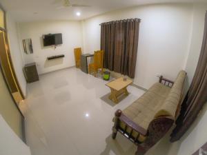 a living room with a couch and a table and a tv at Town Hub in Valāncheri