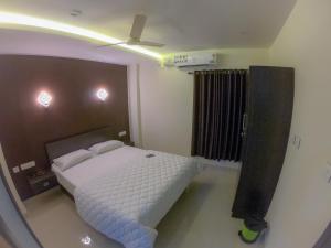 a bedroom with a bed and a ceiling fan at Town Hub in Valāncheri