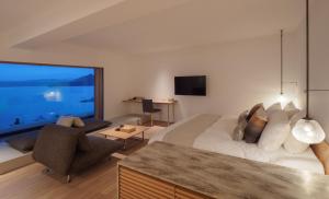 WE Hotel Toya في بحيرة تويا: غرفة نوم بسرير كبير ونافذة كبيرة